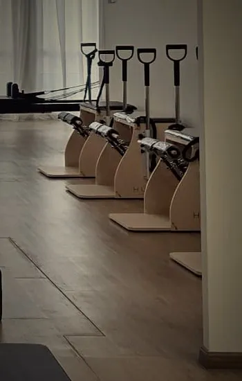 Pilates chairs in pale wood at the back of the studio